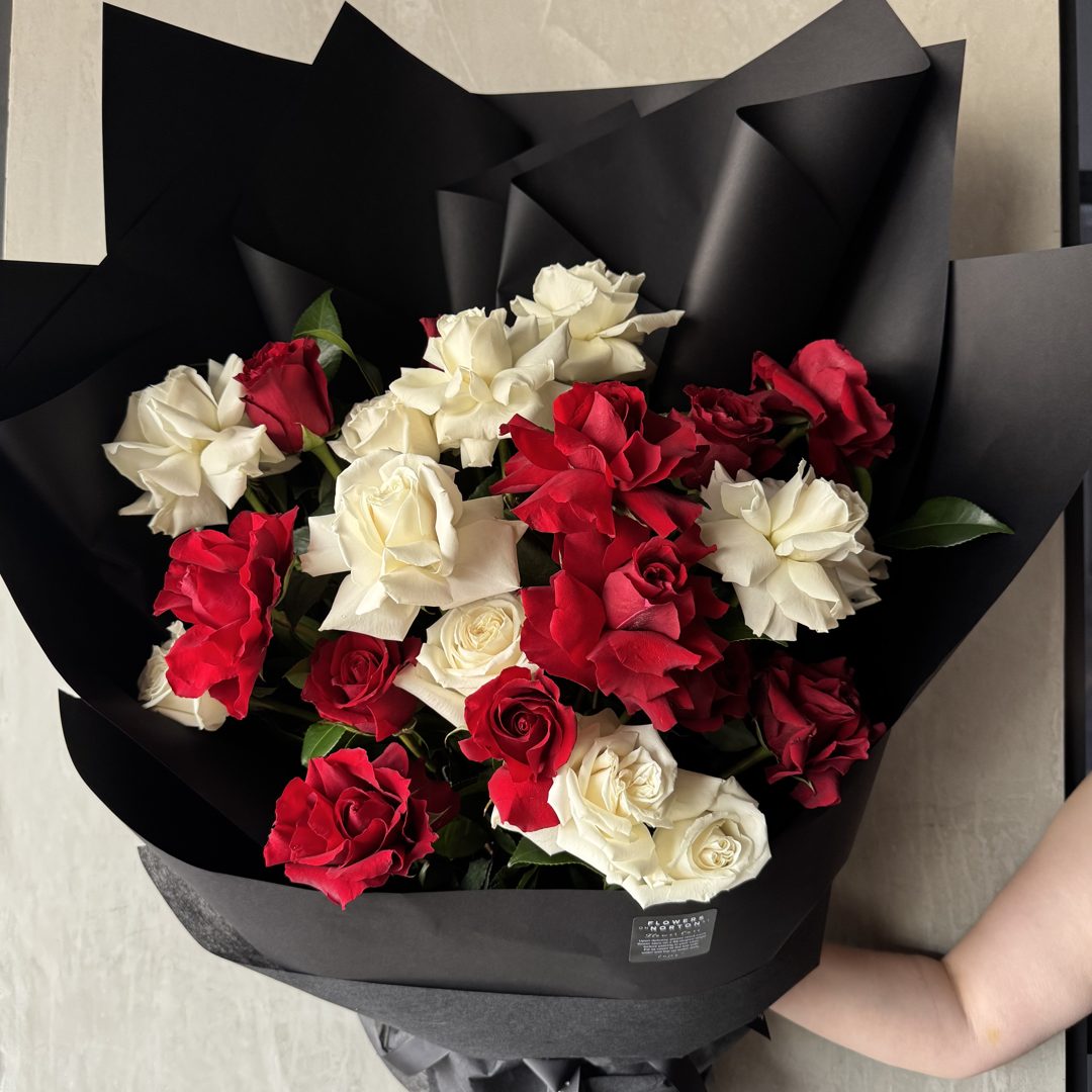 Red and white roses in a black wrap